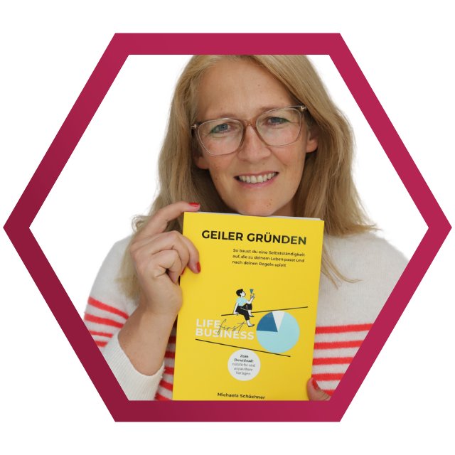Michaela Schächner lächelt und hält ihr Buch vor den Körper